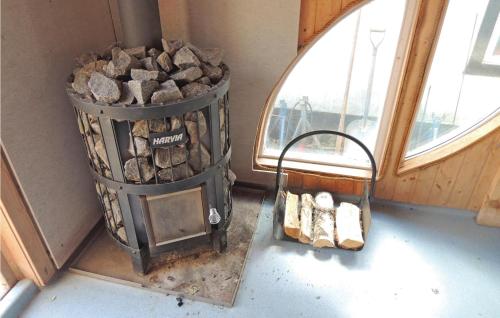 a barrel of fire wood next to a window at Pet Friendly Home In Tranås With Sauna in Tranås
