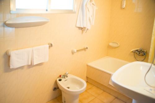 a bathroom with a white toilet and a sink at Hotel Cachalote in Portonovo
