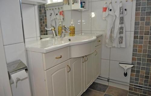 een badkamer met een witte wastafel en een spiegel bij Beautiful Home In Vstra Frlunda With 3 Bedrooms, Sauna And Wifi in Göteborg
