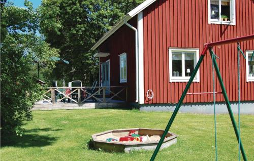 a red building with a sandbox in front of a house at Stunning Home In Vrigstad With Wifi in Vrigstad
