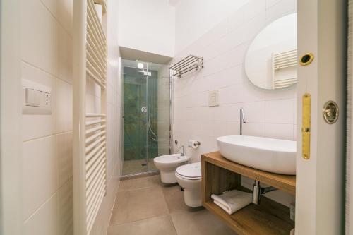 a white bathroom with a sink and a toilet at Arco Gentile in Bitonto
