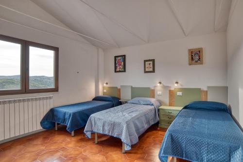 Habitación hospitalaria con 2 camas y ventana en Ostello Portabene, en Montelaterone