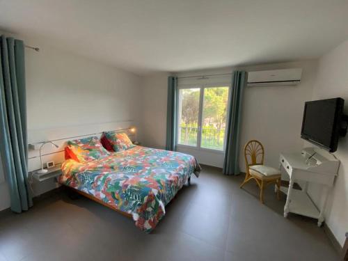 a bedroom with a bed and a desk and a window at VILLA Saint Raphael Valescure Piscine Clim Wifi Golf in Saint-Raphaël