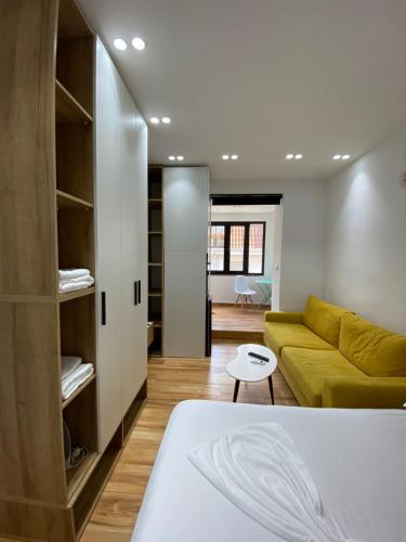 ein Wohnzimmer mit einem gelben Sofa und einem Tisch in der Unterkunft Luxury Apartment in Blloku area in Tirana