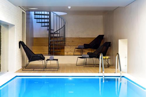 a person sitting on a chair in a swimming pool at Pousada de Lisboa - Small Luxury Hotels Of The World in Lisbon