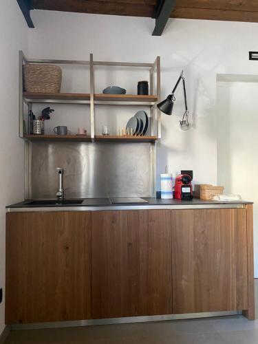 a kitchen with a sink and wooden cabinets at Le dimore di Palagonia in Bagheria