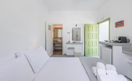 a kitchen with white walls and a green door at Pente Elies Milos in Pollonia
