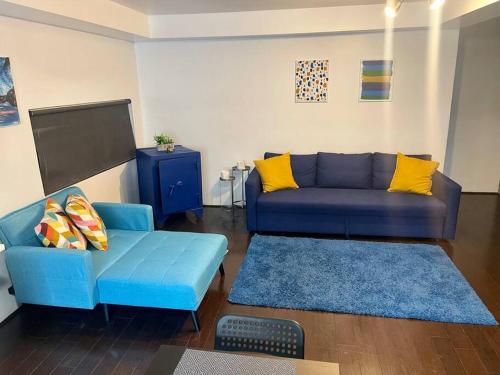 a living room with a blue couch and a tv at El Rincón Azul. Zona Dorada. in Tijuana
