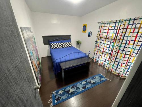 a bedroom with a blue bed and a large window at El Rincón Azul. Zona Dorada. in Tijuana