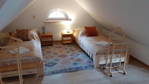 Zimmer im Dachgeschoss mit 2 Betten und einem Fenster in der Unterkunft Dworek POD DĘBEM in Niwiska