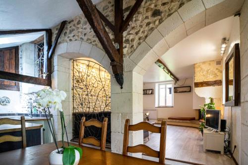 - un salon avec une cheminée, une table et des chaises dans l'établissement Maison de charme à proximité de Pau - 3 chambres - 6 p - Jardin, à Sendets