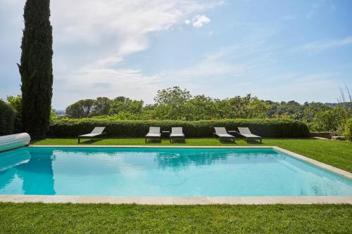 uma piscina com duas espreguiçadeiras num quintal em Appart13 piscine chauffée de luxe Belvoir13 à 10 min d Aix em Aix-en-Provence
