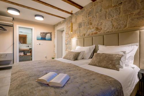 a bedroom with a large bed with two books on it at Old Spalatrum Luxury Rooms in Split