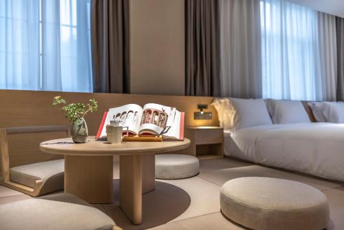 a hotel room with a bed and a coffee table at HOTEL ANDI Townscape Wuhan in Wuhan