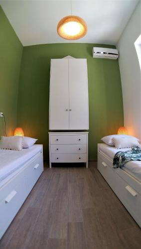 a green room with two beds and a white cabinet at Villa Miranda in Halki