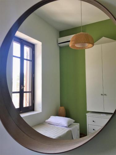 a mirror in a room with a bed and a window at Villa Miranda in Halki