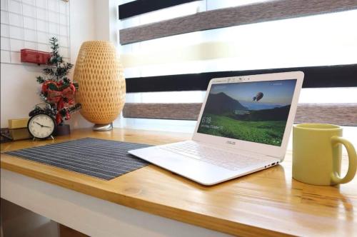 einen Laptop auf einem hölzernen Schreibtisch in der Unterkunft Tagaytay Staycation 1Br w/ Balcony at SMDC Cool Suites in Tagaytay