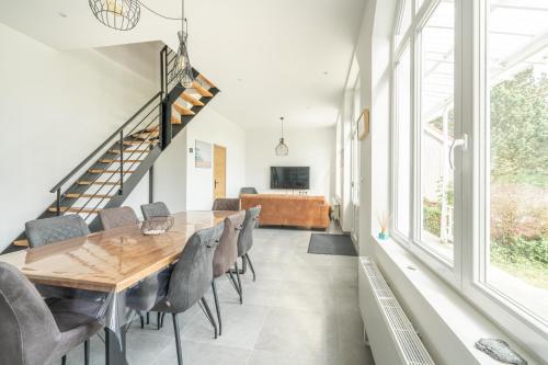 Un comedor con mesa y sillas de madera. en Lumière espace et convivialité à 2 pas de Wimereux, en Wimille