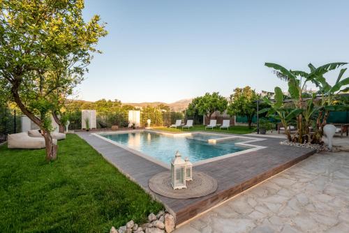 ein Schwimmbad in der Mitte eines Gartens in der Unterkunft Elenas Village house - Dream apt w Pool & Terrace in Alikianós