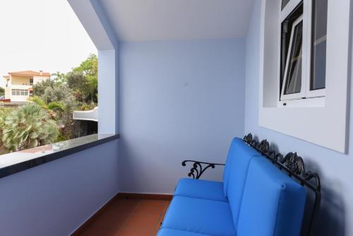 a blue couch in a room with a window at Quinta da Paz in Caniço