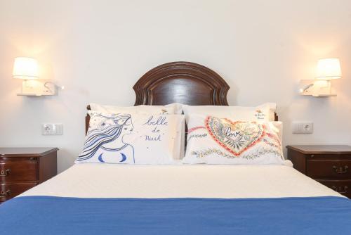 a bed with two pillows and a sign on it at Quinta da Paz in Caniço