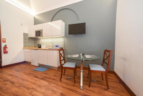 a small kitchen with a table and chairs in a room at Quinta da Paz in Caniço