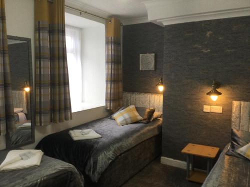 a bedroom with a large bed and a large window at TREVONE, Llandudno in Llandudno