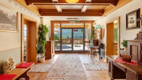 a living room with a door open to a patio at Biovita Hotel Alpi in Sesto