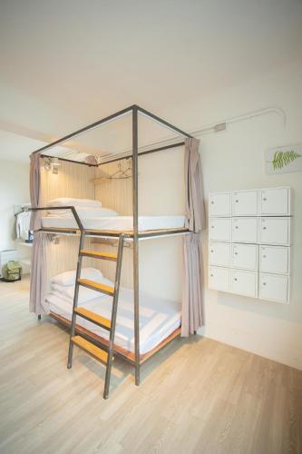 a bunk bed with a ladder in a room at Corner Hostel & Cafe in Taipei