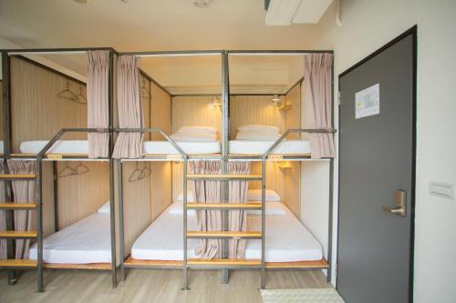 a room with three bunk beds in a hostel at Corner Hostel & Cafe in Taipei