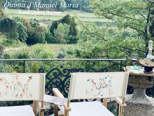 Duas cadeiras brancas sentadas numa varanda com uma mesa em Amarante-Quinta D’Manuel Maria, Rural Charm Houses em Amarante