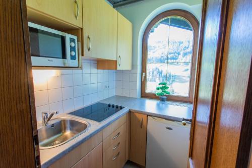 cocina con fregadero y ventana en Huberhof 10 by Alpenidyll Apartments, en Schladming