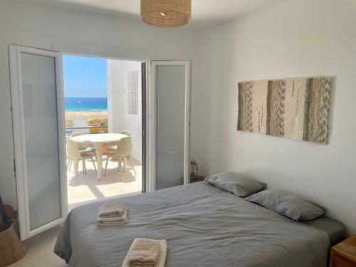 Schlafzimmer mit einem Bett und Meerblick in der Unterkunft Los Lances Beach Apartments in Tarifa