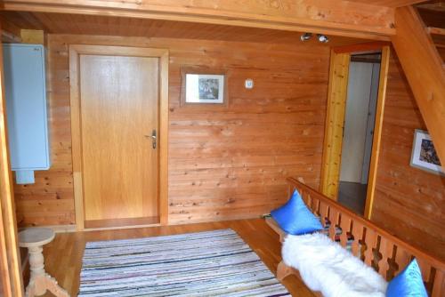 a room with wooden walls and a staircase with blue pillows at Ferienhaus Obersäuling in Stummerberg