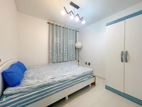 a bedroom with a bed and a window at Petit House in Sokcho