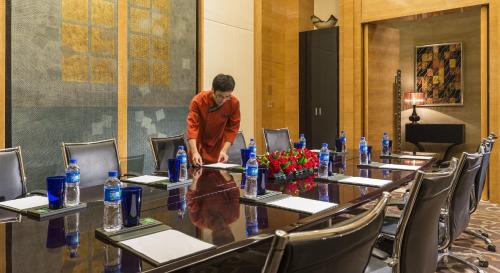 a man standing at a long table in a conference room at InterContinental Shijiazhuang by IHG in Shijiazhuang