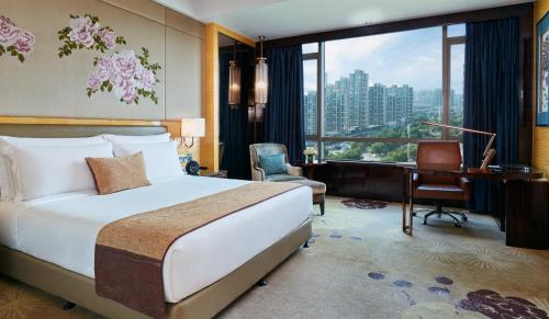 a hotel room with a bed and a desk and a window at InterContinental Shijiazhuang, an IHG Hotel in Shijiazhuang