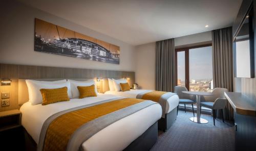 マンチェスターにあるMaldron Hotel Manchester City Centreのベッド2台とデスクが備わるホテルルームです。