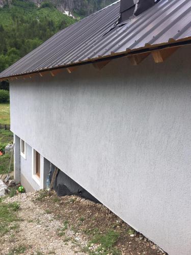 a side of a house with a metal roof at Bujtina Sherifaj in Valbonë
