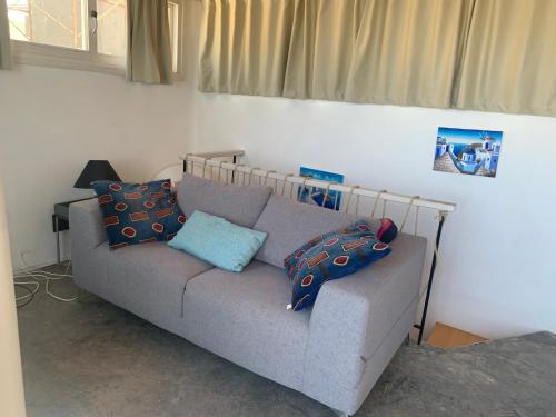 a living room with a couch with pillows on it at ROMANTIC HOUSE 6 STEPS FROM THE SEA in Mochlos