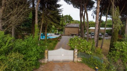une allée avec une clôture blanche et une maison dans l'établissement Dependance Villa Settecamini, à Porano