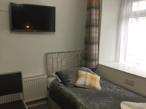 a bedroom with a bed with a pillow and a window at THE TREVONE, Llandudno in Llandudno