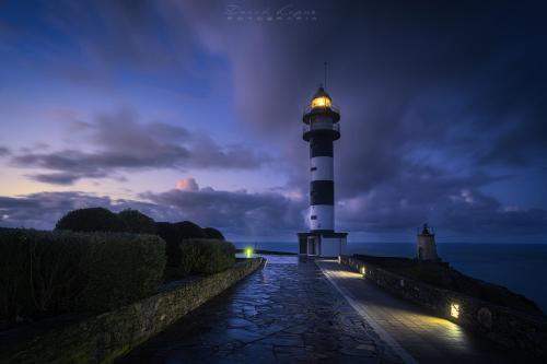 a lighthouse with a light on top of it at night at Hotel Rural La Sobreisla in Puerto de Vega