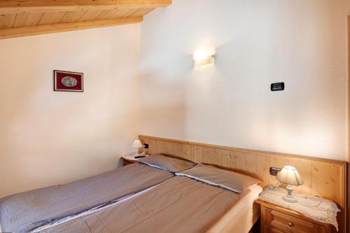 a small bedroom with a bed and two night stands at Appartamento Jolly in Livigno