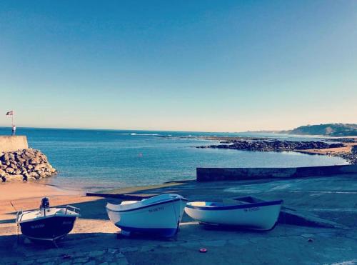 three boats sitting on the beach near the water at APPARTEMENT T2 GUETHARY CENITZ in Guéthary