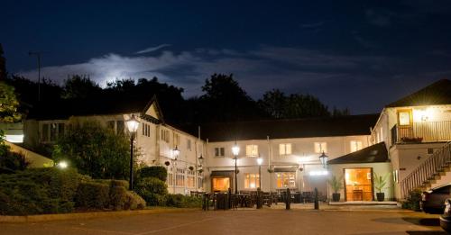 a large white building with lights at night at Rose of York in Richmond upon Thames