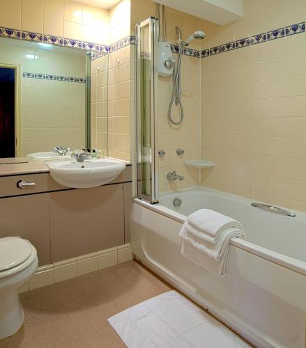 a bathroom with a tub and a sink and a toilet at Rose of York in Richmond upon Thames
