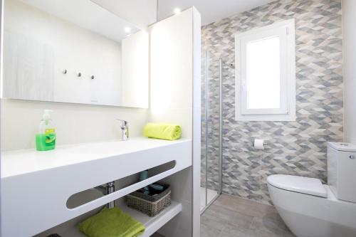 een badkamer met een wastafel, een toilet en een raam bij Villa Vistamar in Punta Grossa