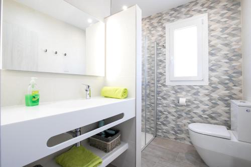 a bathroom with a sink and a toilet and a window at Villa Vistamar in Punta Grossa