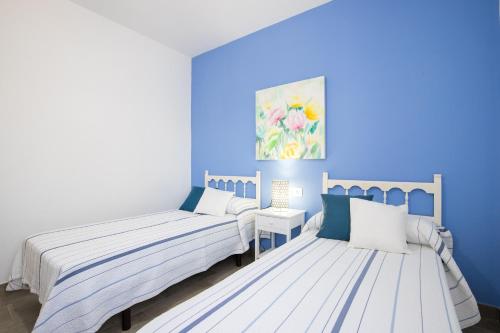 two beds in a room with blue walls at Villa Vistamar in Punta Grossa